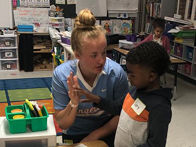 An alumni volunteer with 2 students